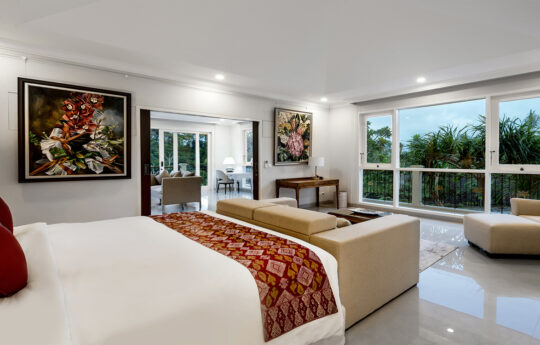 large bedroom with king bed and sitting room with jungle views