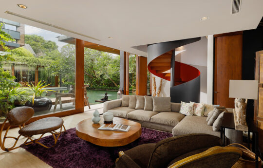 L shaped sofa in living area with views to pool and garden