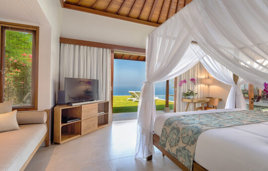 Master bedroom overlooking the Indian Ocean with tv and canopy over bed