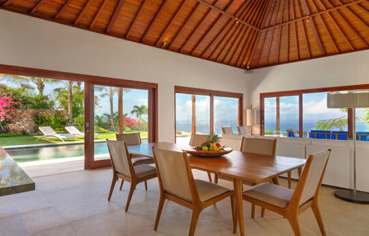 Modern dining and living spaces overlooking the ocean with pool views