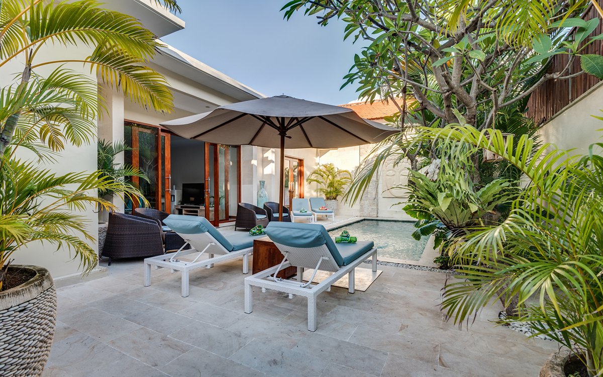 Swimming pool with two day beds under sunbrella