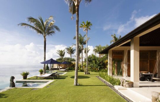 villa exterior with grass garden area and pool on the ocean
