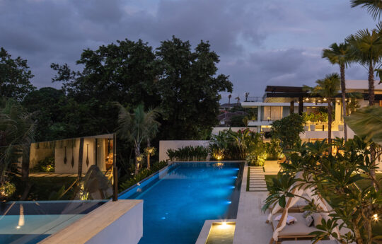 Serene vila at dusk with view of pool with lights on