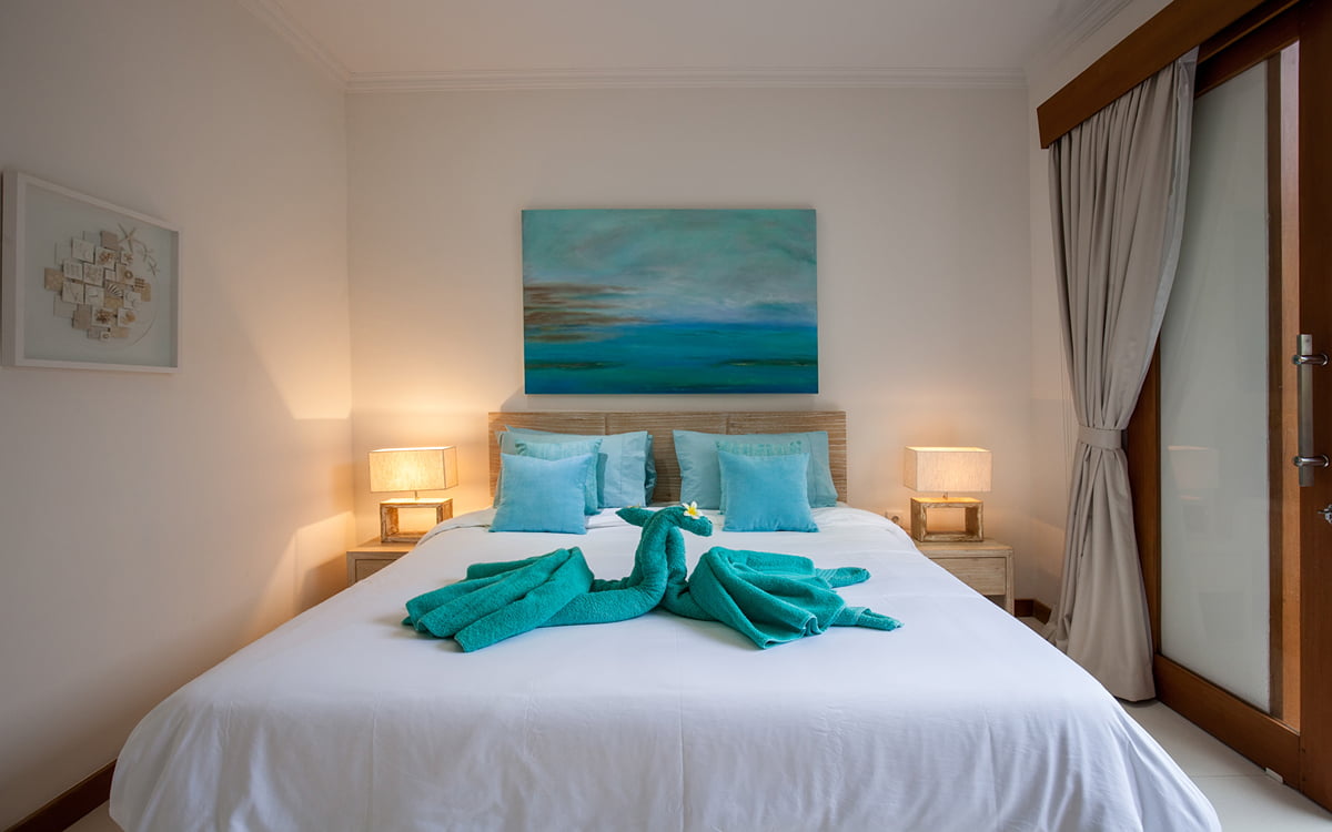 Bed in room with towels on bed in shape of swan