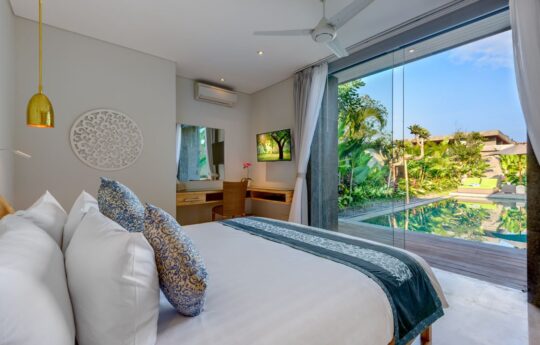 View of swimming pool from bedroom on sunny day