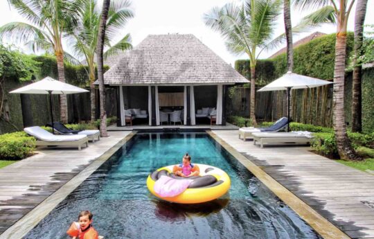 two children playing in swimming pool on hot day