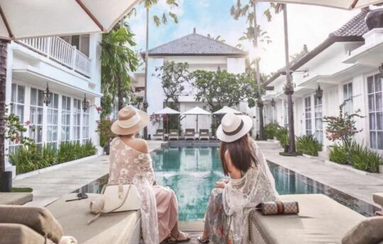 2 women sitting by a private swimming pool in bali