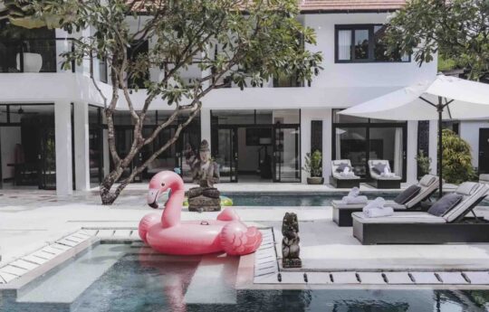 swan blow up toy in swimming pool with villa exterior in background
