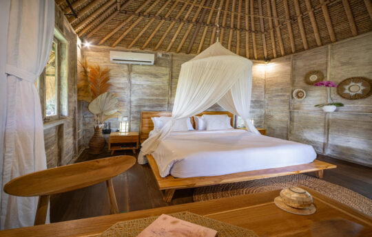 rustic bedroom with mosquito net in villa
