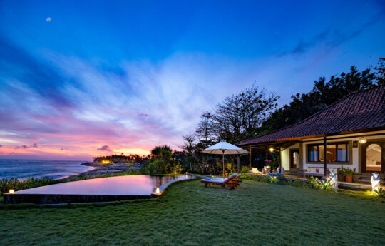 swimming pool and garden views with beach and villa in background