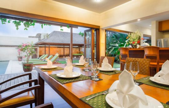 Dining table of villa with views to exterior and outdoor gazebo area