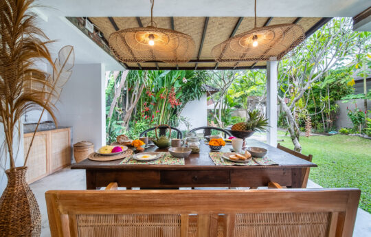 Tropical style dining table with plates and views of garden