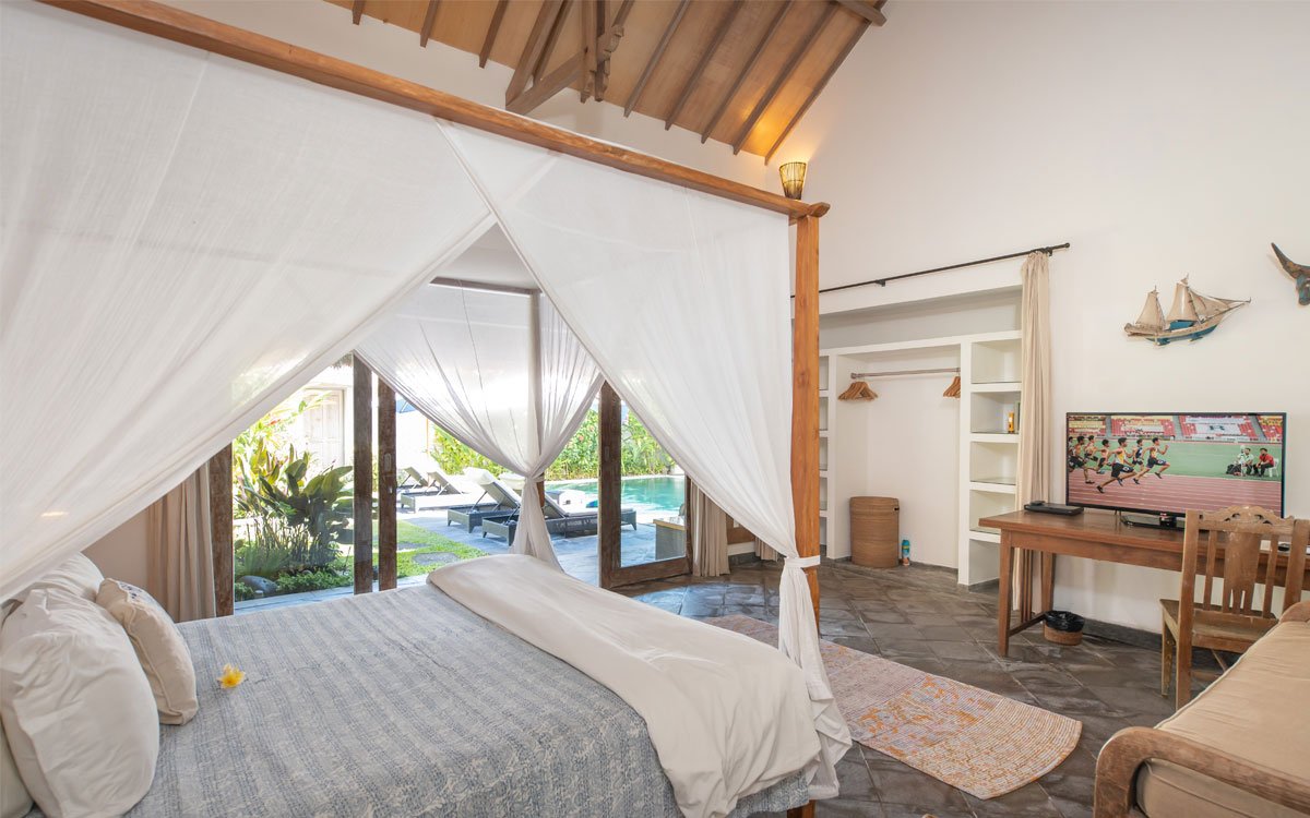 Modern bedroom in villa with TV and views of pool