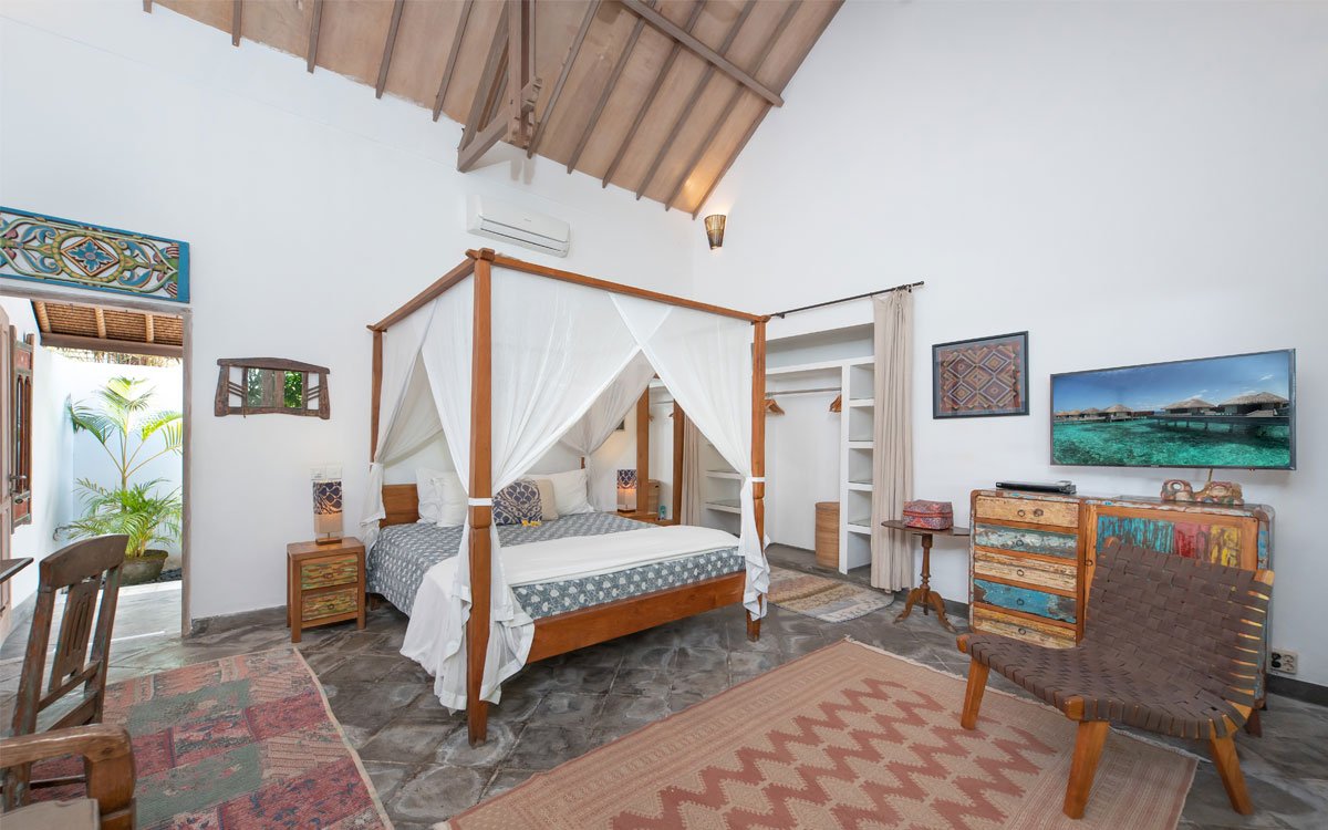 Modern bedroom with high ceiling and king size bed with mosquito net