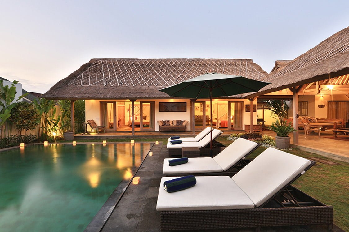Large swimming pool under dusk Bali skies with villa in back ground