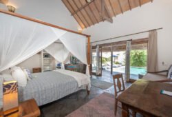 Book Villa Damai Manis - contact Bali Villa Escapes Modern bedroom with bed and views of swimming pool and garden