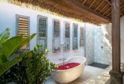 Book Villa Damai Manis - contact Bali Villa Escapes Rustic outdoor bathroom with bathtub full of petals