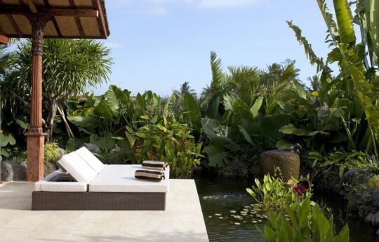 Outdoor daybeds by the fishpond in villa