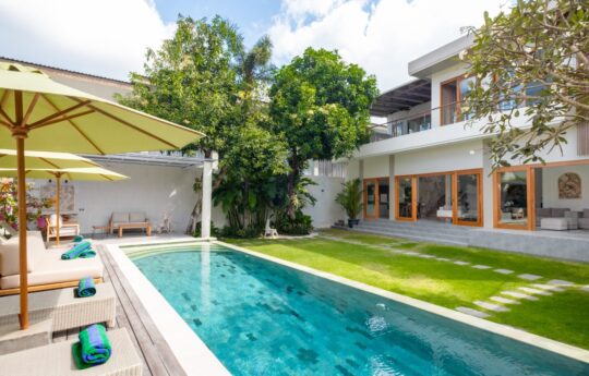 Swimming pool with ample grass area surrounds with comfy day beds