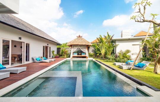 View of length of swimming pool with gazebo in background and grassy garden area