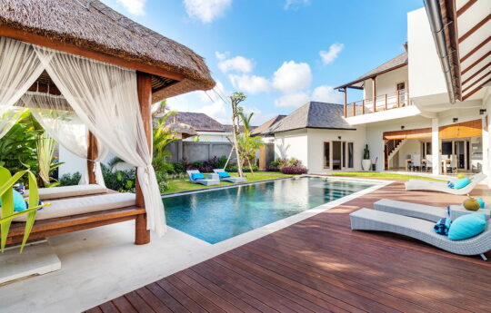 Day beds and gazebo by swimming pool with deck areas and views to 2 storey villa