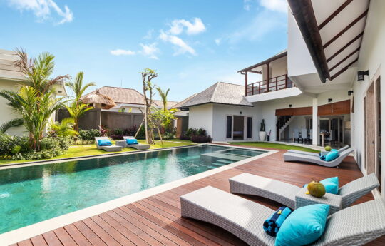 Pool and daybed views with large villa in background