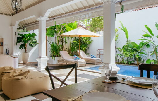 View of swimming pool from living areas with day beds in background