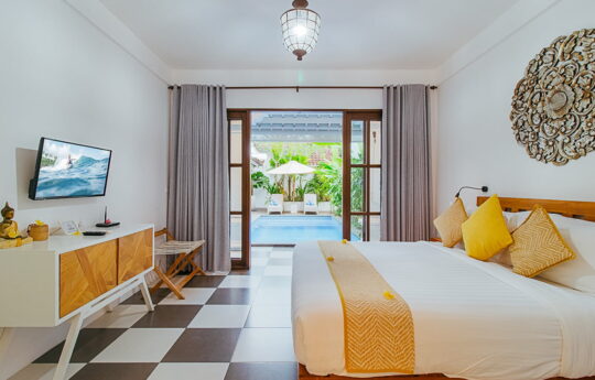 Modern bedroom with king sized bed and view to pool