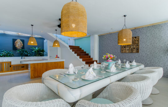 Dining table with chairs and staircase in background