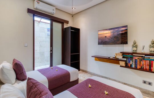 Modern bedroom with two single beds and flat screen tv