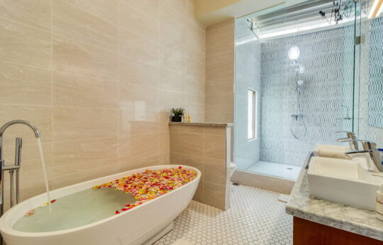 Bathroom in villa with vanity and bathtub with petals