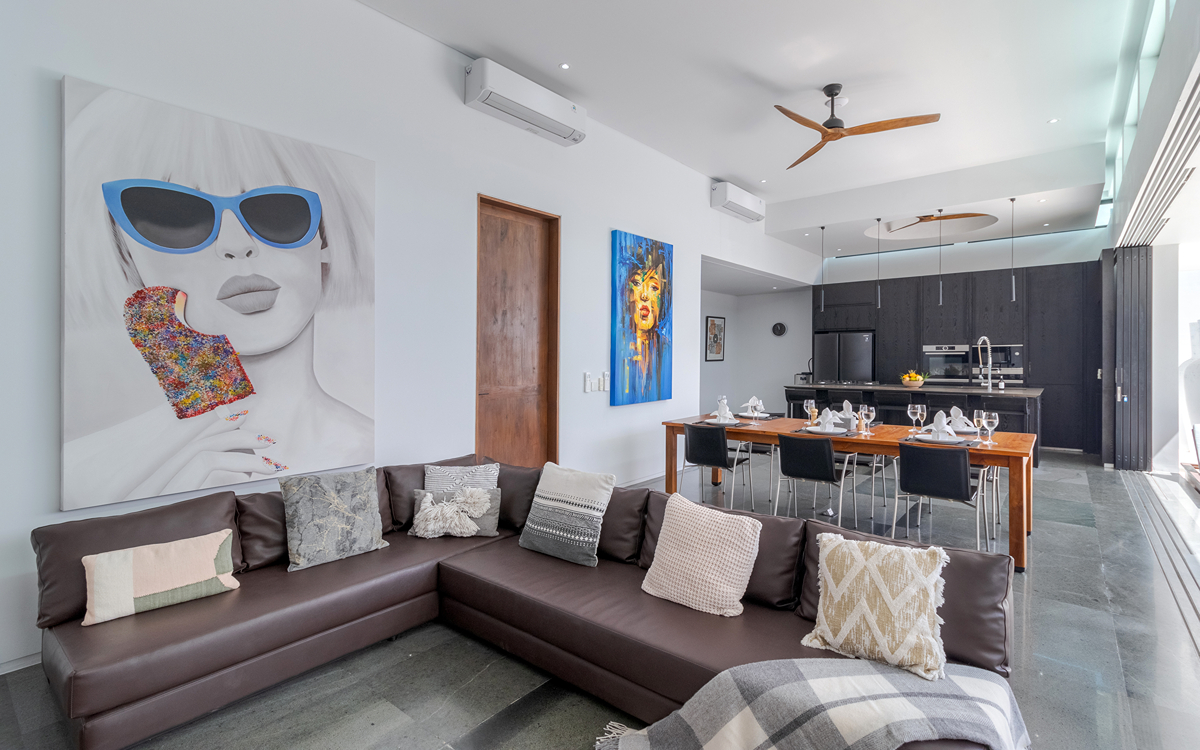 Whole view of villa with sofa, dining table and kitchen