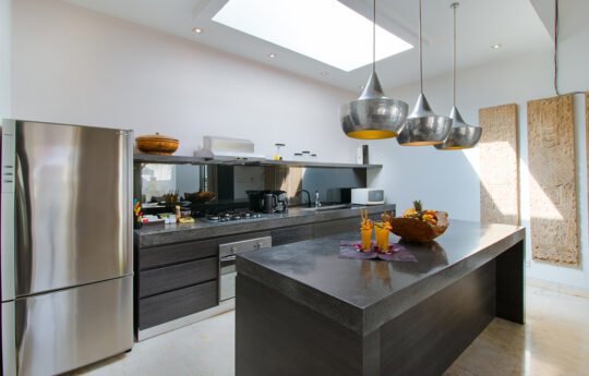 Modern kitchen of villa with island bench and cooking area