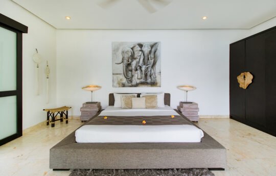 King size bed in villa lanai with painting in background