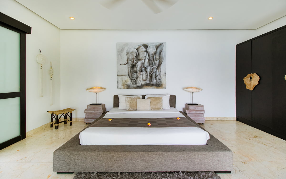 King size bed in villa lanai with painting in background