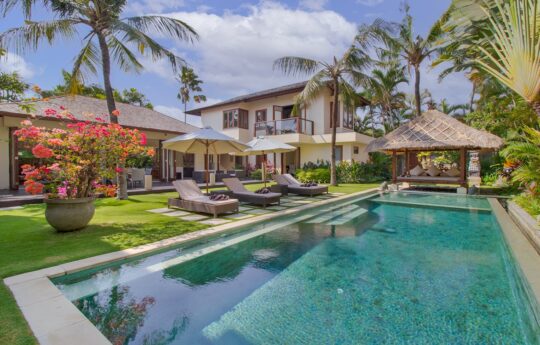 Daytime views of swimming pool with day beds at Villa Josuloma in Seminyak
