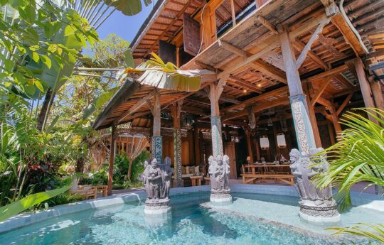 Villa Yin View to wooden villa exterior with swimming pool and garden in foreground on sunny day