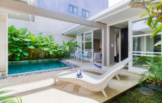 Swimming pool, day beds and views of single level villa exteriors during day