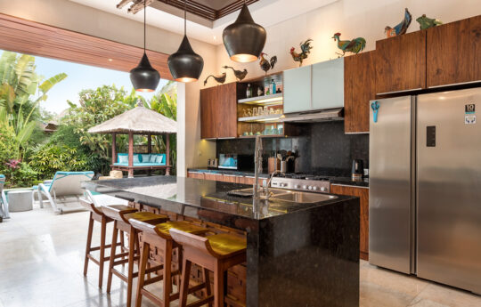 Modern kitchen with bar stools with views to garden and pool area