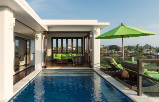 Upstairs pool area of villa with rice field views and day beds