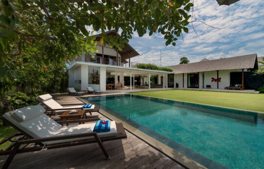 Villa Kavya's swimming pool and day beds with view of villa in background