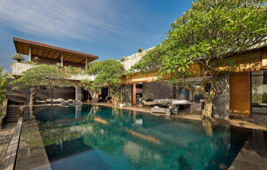 Villa Mana, Canggu Vierw of swimming pool during day with 2 level Bali villa exterior in background