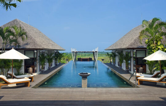 Swimming pool with rice field views and two villa pavillions