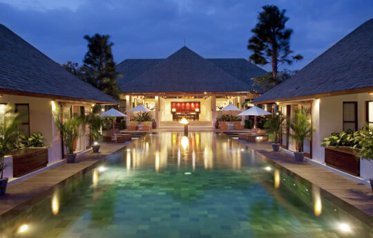 Villa at night with view of pool