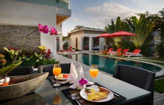 Villa Miro view of swimming pool with breakfast on table in foreground early morning