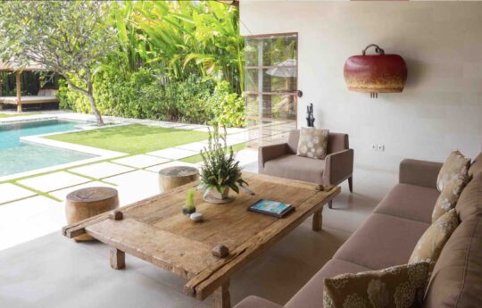 coffee table and sofa in living room with view to pool