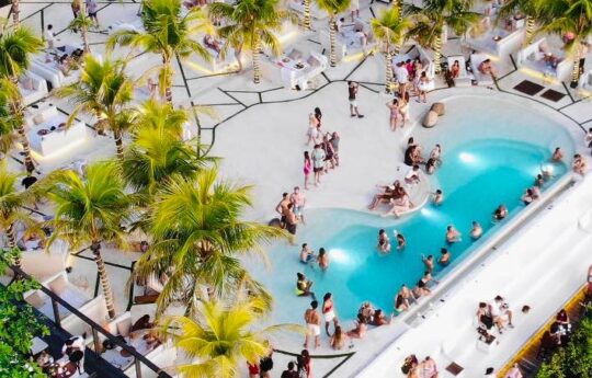 Aerial view of beach club in bali with swimming pool on sunny day