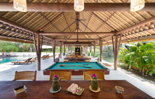Billiard table under pavilion next to outdoor dining table