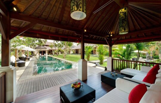 view to pool from lounge area with garden views