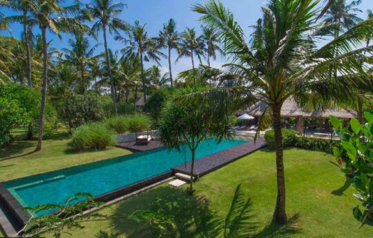 large swimming pool with grassy garden area and villa exterior